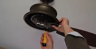 Electrician installing ceiling fan mounting bracket and fixture in Chico, CA