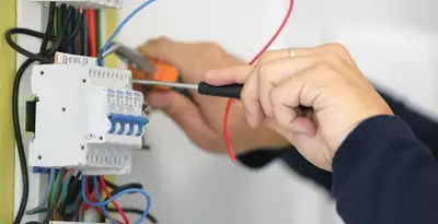 Electrician installing and adjusting circuit breakers in an electrical panel in Chico, CA