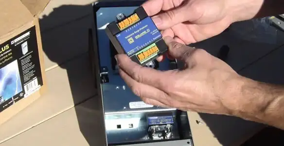 Electrician installing whole home surge protection unit inside main electrical panel in Chico, CA