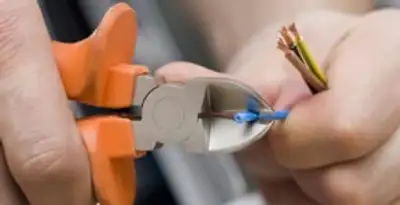 licensed electrician performing precise wire cutting and preparation during electrical service in Chico, CA