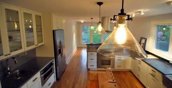 Residential electrician installing modern indoor light fixture in a home in Chico, CA
