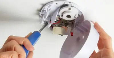 Certified technician wiring smoke detector during installation in Chico, CA